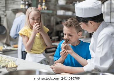 Boy and girl smelling food from female chef in cooking class - Powered by Shutterstock