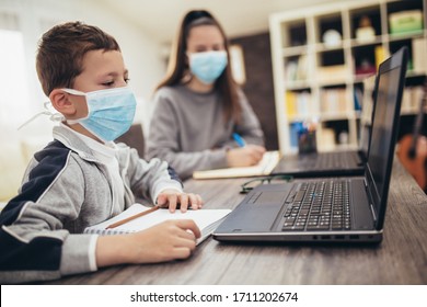 Boy and girl studies at home, wear protective masks, and doing school homework. Distance learning online education. - Powered by Shutterstock