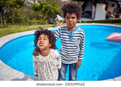  boy and girl take center stage, radiating happiness. The girl, with a mischievous grin, playfully sticks out her tongue, adding a touch of spontaneity to the moment. - Powered by Shutterstock