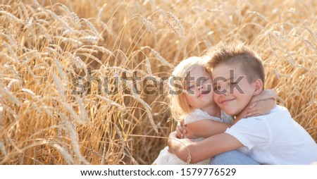 boy and girl walking in field of wheat
