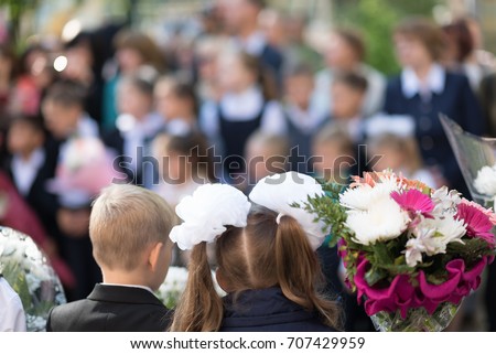 boy and girls with flowers on the line in the school on the first day of school - September 1.