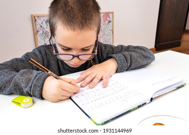 Boy with glasses doing homework at home.