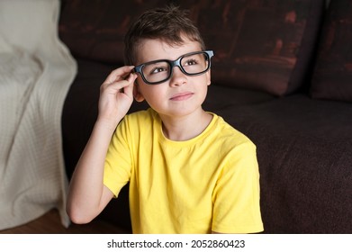a boy with glasses looks into the distance. Smart guy . Studying at home