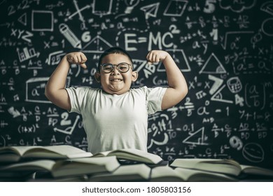 A boy with glasses sitting in the study and with both arms perpendicular