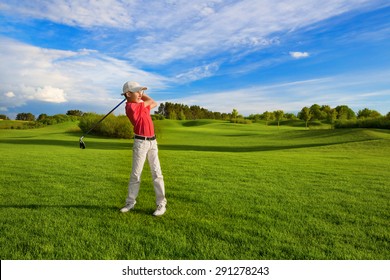 Boy golf player hitting by iron from fairway