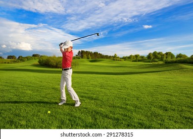Boy golf player hitting by iron from fairway