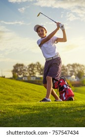 Boy golf player hitting by iron from fairway at golf course