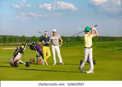 Boy golfer with parents plaing golf at sunny day