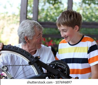 Boy And Grandfather Fixing Bike