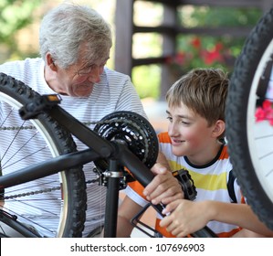 Boy And Grandfather Fixing Bike