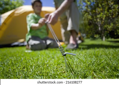 Boy and grandfather setting up tent - Powered by Shutterstock