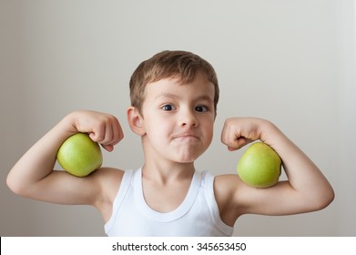 boy with green apples showing biceps