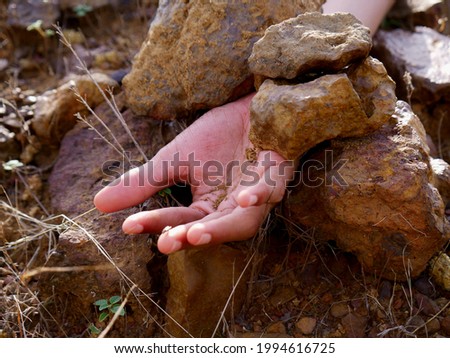 Boy hand presented down the stone rocks, land slide concept
