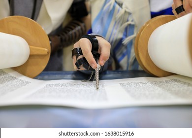 Boy Hand Reading The Jewish Torah At Bar Mitzvah. Torah Reading Hand Is A Sacred Tool Used To Point To The Text During Reading In The Torah Scroll. 