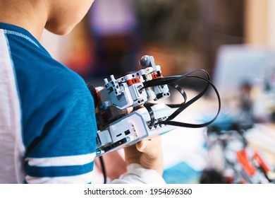 Boy Hands Holding Robotic Model Prototype And Training Microchip Controlled Robot To Perform Actions Based On Programming For His Science Project. Child Education, Innovation, Technology And Science.