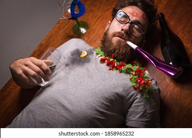 Boy With A Hangover After A New Year's Eve Party Lying On The Floor.