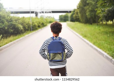 Boy happy running to school with his backpack. Schoolboy on his way to the home after school. Mixed african American boy. 