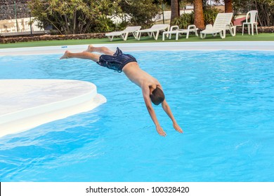 Boy Has Fun Jumping In The Pool