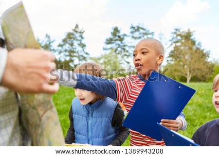Boy has an idea as a clever detective on the scavenger hunt as a game of terrain in the park