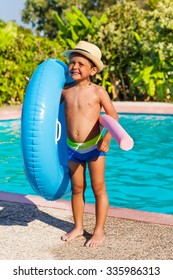 Boy In Hat Holding Inflatable Ring And Pool Noodle