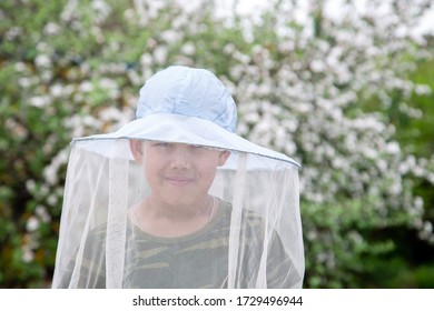 boy in a hat with a net for insect protection