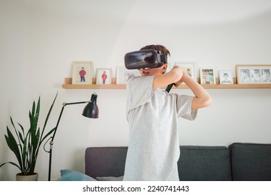 Boy having fun playing simulation games, using virtual reality headset and controller. Children and modern technology concept.