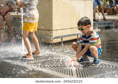 Boy having fun in water fountains. Child playing with a city fountain on hot summer day. Happy kids having fun in fountain. Summer weather. Active leisure, lifestyle and vacation. - Powered by Shutterstock