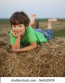boy in a haystack in the field in autumn
