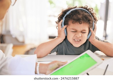 Boy, headphones and doctor or tablet for stress test, autism diagnosis and sensory overwhelmed. Male person, child and audio or sound for anxiety or pain, online and green screen and psychologist - Powered by Shutterstock