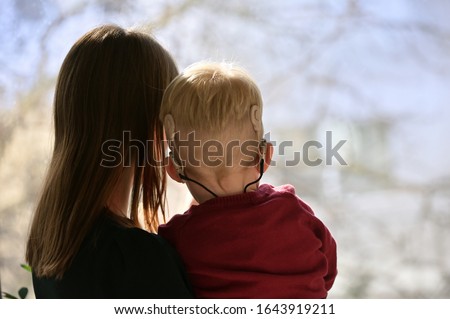 A Boy With A Hearing Aids And Cochlear Implants and his mother