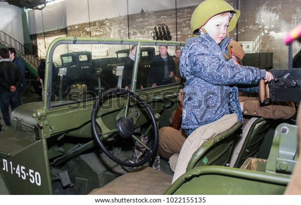 A boy in a helmet in a military\
car.\
St. Petersburg, Russia - 7 May, 2017.\
Visitor in the\
exhibition pavilion of the Patriotic Association of\
Lenrezerv.