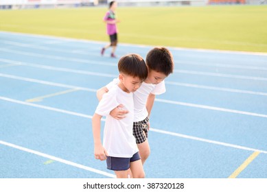 Boy help each other to run on the running track.