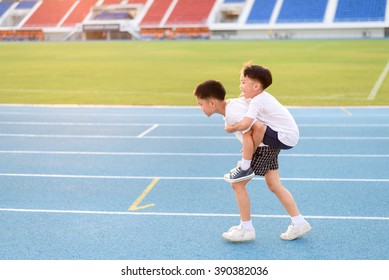 Boy help each other to run on the running track.