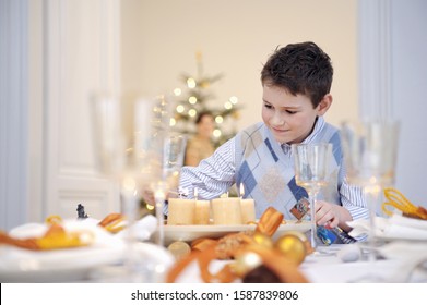 Boy Helping Set Table At Christmastime