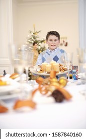 Boy Helping Set Table At Christmastime