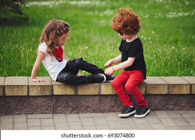 Boy Helps Little Girl Tie Shoelaces