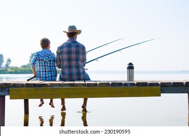 boy and his father fishing together from a pier - Powered by Shutterstock