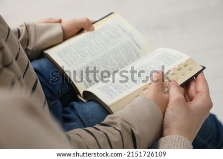 Boy and his godparent reading Bible together, closeup