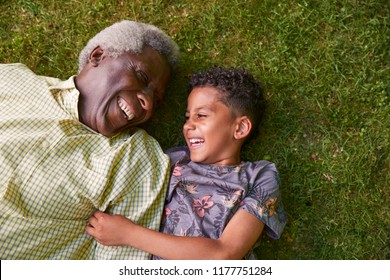 Boy And His Granddad Lying On Grass, Overhead Close Up