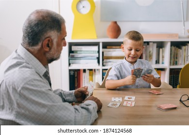 boy with his grandfather playing cards at home - Powered by Shutterstock