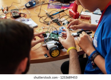 Boy and his mentor working on a self made computer controlled vehicle