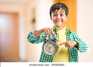 Boy Holding An Antique Clock Inside House