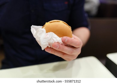 Boy Holding A Burger In One Hand. Man With A Delicious Tasty Fast Food Cheeseburger. The Concept Of Fast Food. Tasty Unhealthy Burger Sandwich In Hands, Ready To Eat