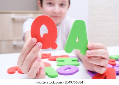 A Boy Holding Colorful Letters Q And A, Questions And Answers Concept, Solvation Kids Problems