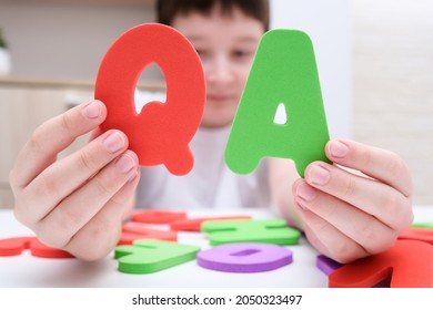 A Boy Holding Colorful Letters Q And A, Questions And Answers Concept, Solvation Kids Problems