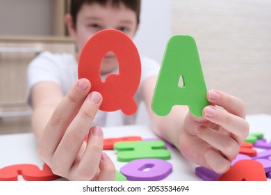 A Boy Holding Colorful Letters Q And A, Questions And Answers Concept, Solvation Kids Problems.