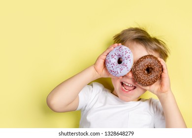 Boy holding donuts by this eyes, bright background, top view - Shutterstock ID 1328648279