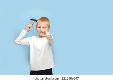 Boy Holding A Hammer And Pointing His Finger Forward With An Ironic Smirk On A Blue Background With Copy Space