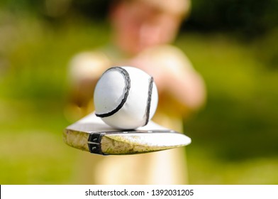 Boy Holding Up A Hurling Bat And Sloitar (ball) Used In The Irish Game Of Hurling.