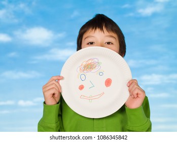 A Boy Holding A Paper Plate With A Drawing On It